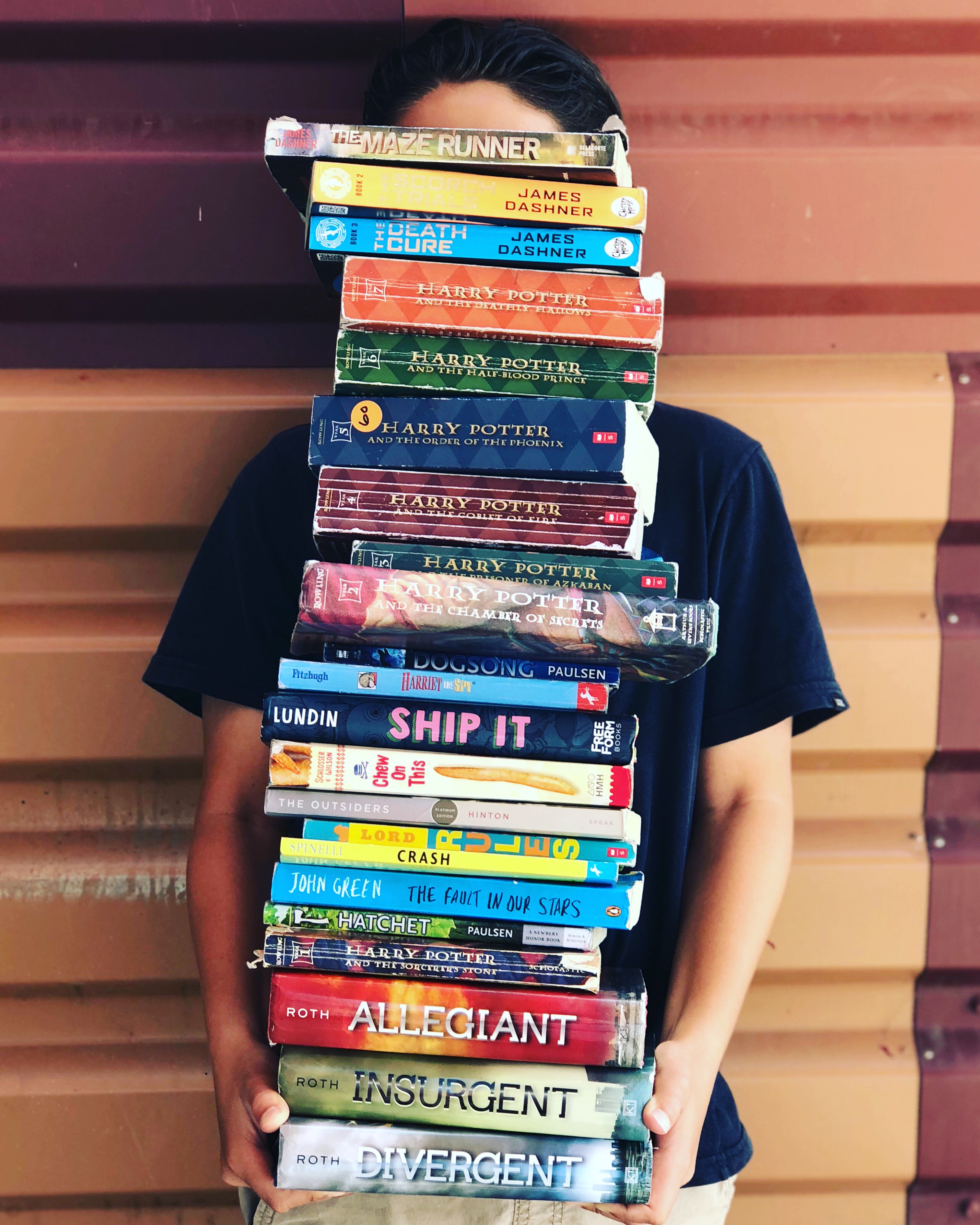 My 7th grade student holding the huge stack of books he read this year